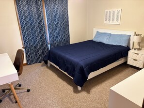 Une chambre à coucher avec un lit, un bureau et une chaise.