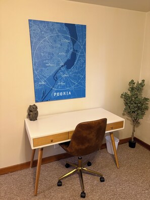 A desk with a map of Peoria on the wall, a small owl decoration, and a potted plant. - Stay in America's Pumpkin Capital! Furnished Apartment Near Peoria Hospitals (Morton)