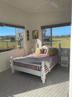 A bedroom with a bed, a nightstand, a window, and a view of the outdoors. - River frontage on Maroochy River, Sunshine Coast! (Maroochy River)