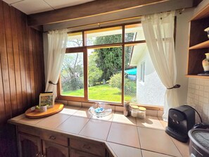 A kitchen with a window, a coffee maker, and a tea kettle. - Escazu Boutique Accommodations & Pool (San Antonio, Escazu)