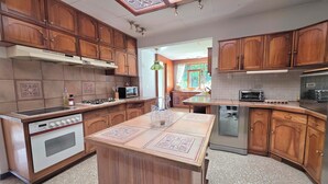 A kitchen with wooden cabinets, a central island, a built-in oven, a microwave, and a dishwasher.