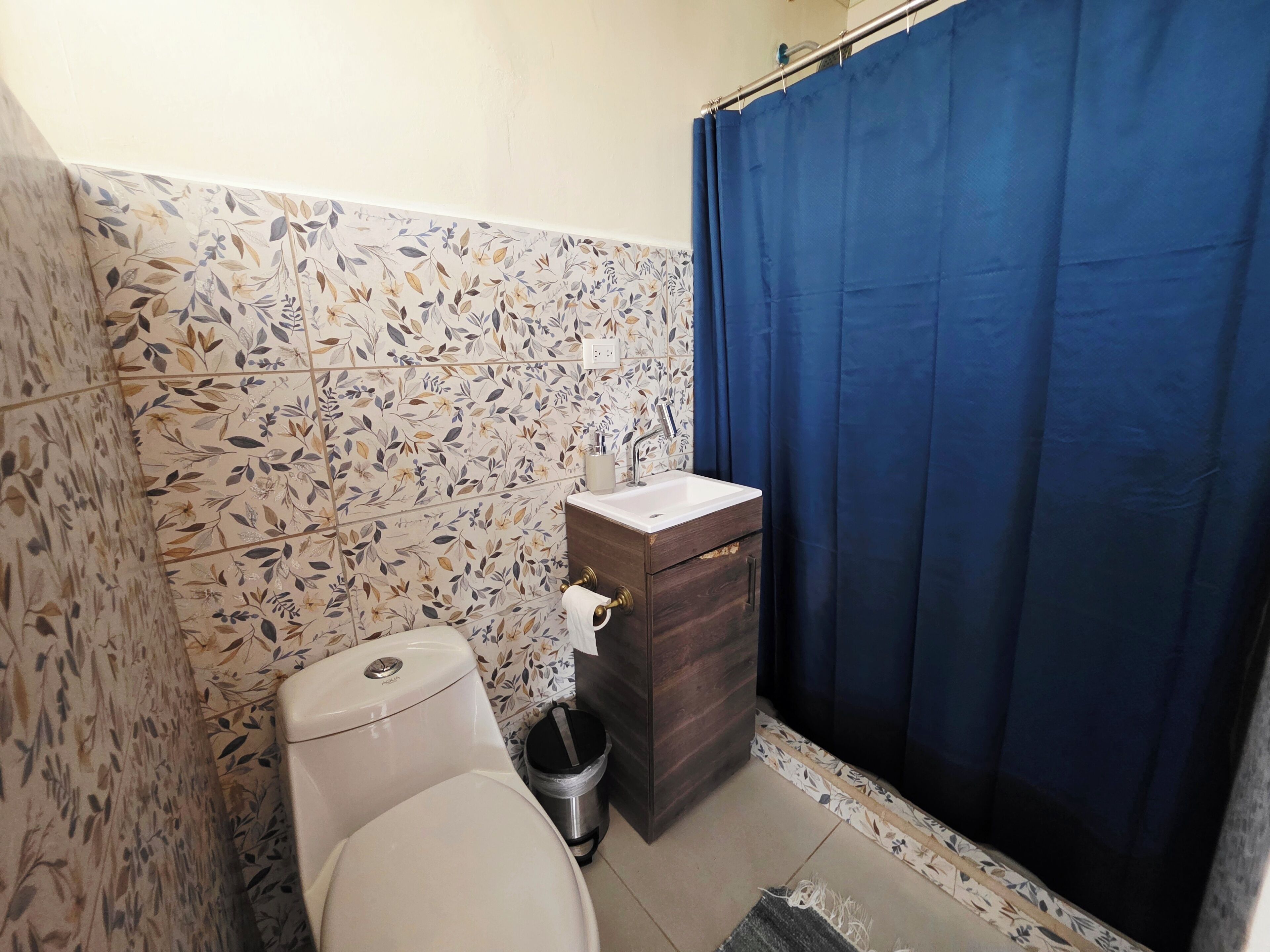 Un baño con inodoro, lavabo y cortina de ducha.