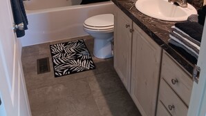 A bathroom with a bathtub, toilet, and sink. There are towels and toiletries on the counter. - 3-bedroom house in peaceful Stacyville  short distance to mt katahdin (Stacyville)