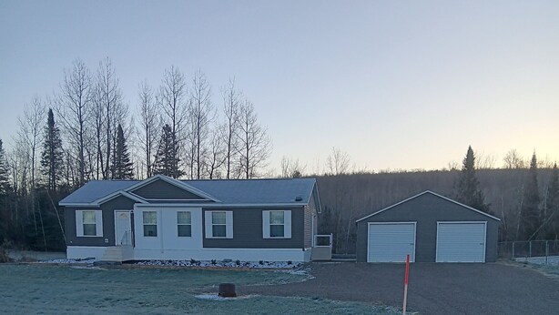 A residential property with a house, garage, and open field. - 3-bedroom house in peaceful Stacyville  short distance to mt katahdin (Stacyville)
