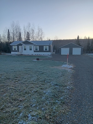 A residential property with a house, garage, and open field.