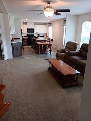 A living room with a sofa, a wooden coffee table, and a dining area with a table and chairs.