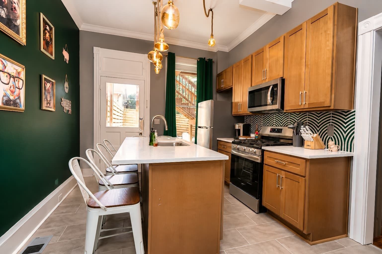 A modern kitchen with wooden cabinets, a central island, stainless steel appliances, and a dining area with a bench.