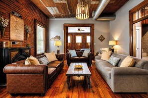 Ein gemütliches Wohnzimmer mit Ledersofas, einem Holztisch und einem Kamin.