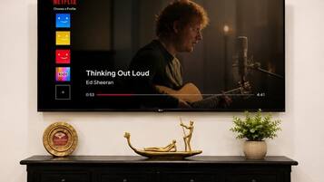A television displaying a music video with a person playing a guitar.