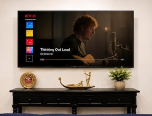 A television displaying a music video with a person playing a guitar.