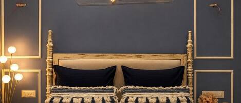 A bedroom with a bed, a neon sign, bedside lamps, and a nightstand.