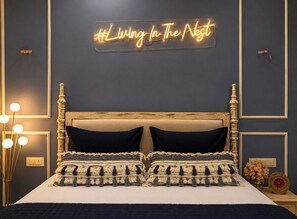 Een slaapkamer met een bed, een neonbord, bedlampen en een nachtkastje.