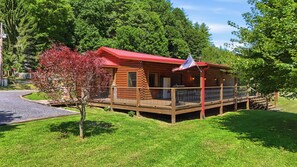 Eine Holzhütte mit rotem Dach, einer Veranda und einer Flagge.