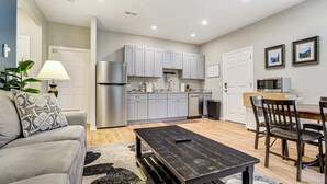 A compact living space with a kitchenette, a dining area, and a seating area. - Ponderosa Glade! Hot Tub & Forest Views by USAFA (Monument)