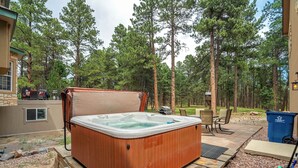 A hot tub in a backyard with a wooden deck, surrounded by trees. - Ponderosa Glade! Hot Tub & Forest Views by USAFA (Monument)