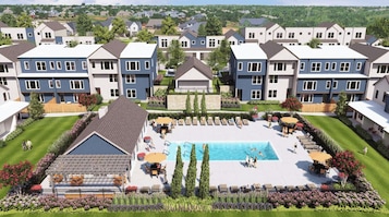 Un complejo residencial con piscina central, varias casas y un césped bien cuidado.