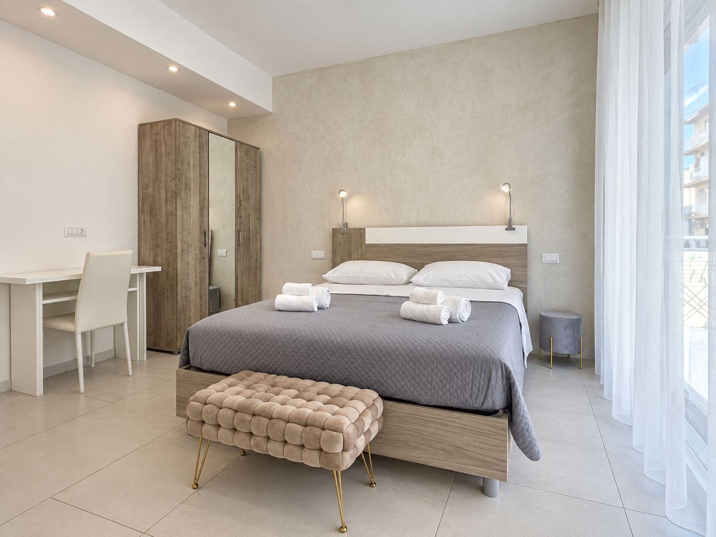 Un dormitorio moderno con una cama, un escritorio y un armario.