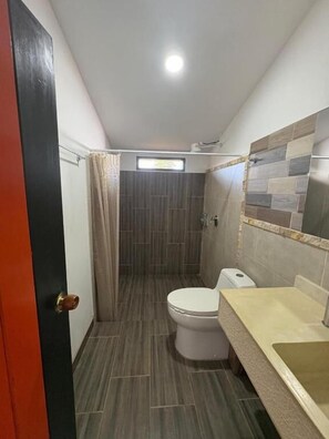 Ein kleines Badezimmer mit Toilette, Waschbecken und Duschbereich.