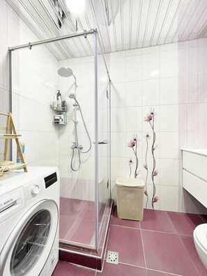 A modern bathroom with a glass-enclosed shower, a washing machine, and a decorative wall with floral patterns. - Bright & Cozy Yerevan Apartment with City View Near City Center & Self Check-in (Yerevan)