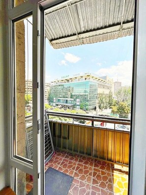 A balcony with a view of a building labeled 'TASHIR' and a tiled floor. - Bright & Cozy Yerevan Apartment with City View Near City Center & Self Check-in (Yerevan)
