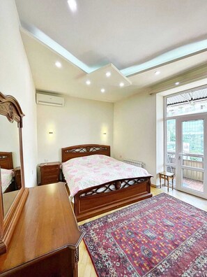 A bedroom with a bed, dresser, and a large window. - Bright & Cozy Yerevan Apartment with City View Near City Center & Self Check-in (Yerevan)