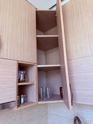 A kitchen with wooden cabinets, a countertop, and a tiled backsplash. - Bright & Cozy Yerevan Apartment with City View Near City Center & Self Check-in (Yerevan)