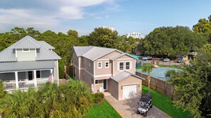 Ein Wohnhaus mit einem zweistöckigen Haus, einer Garage, einem Swimmingpool und einem gepflegten Rasen.