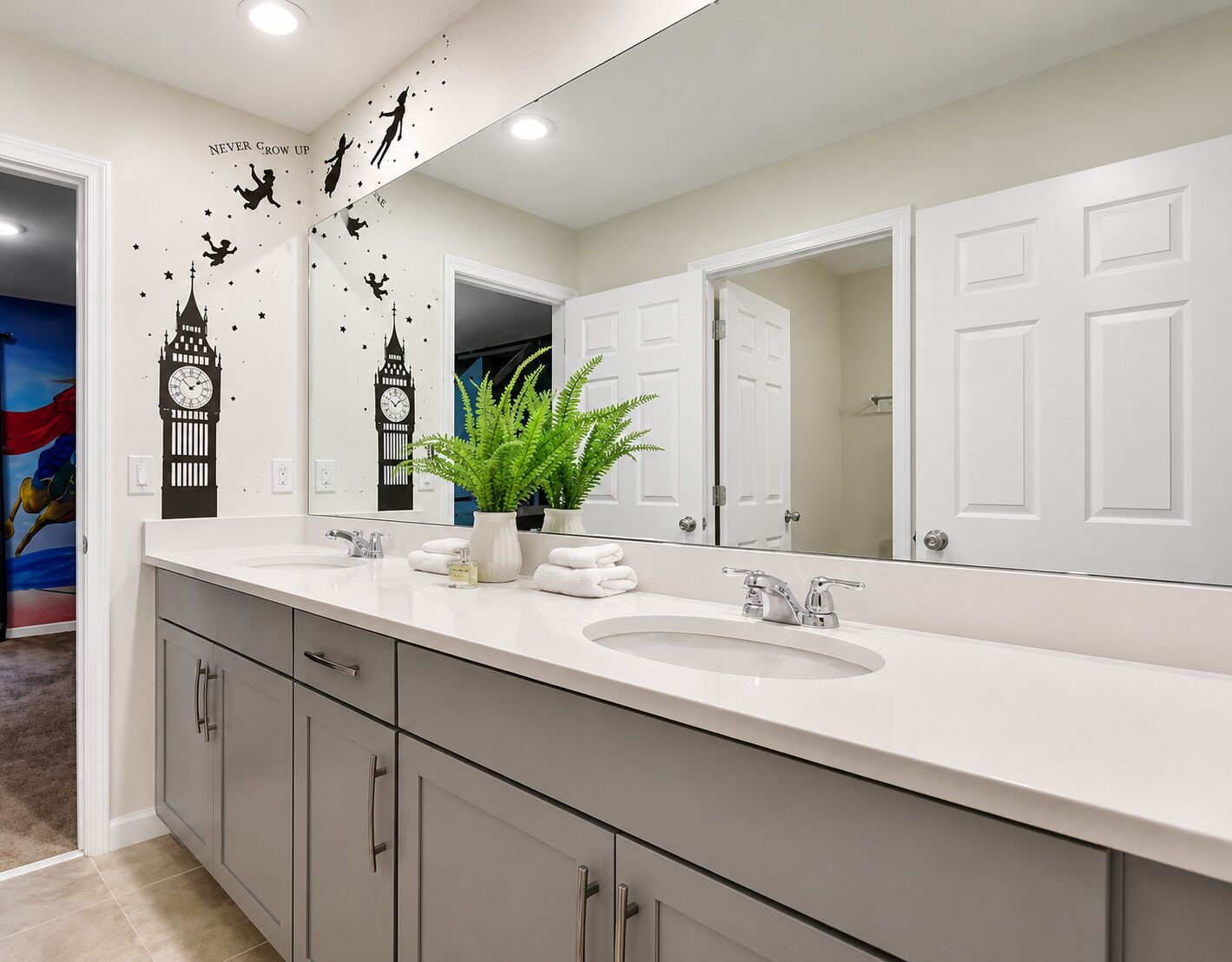 Une salle de bain moderne avec un grand miroir, un lavabo et une plante en pot.