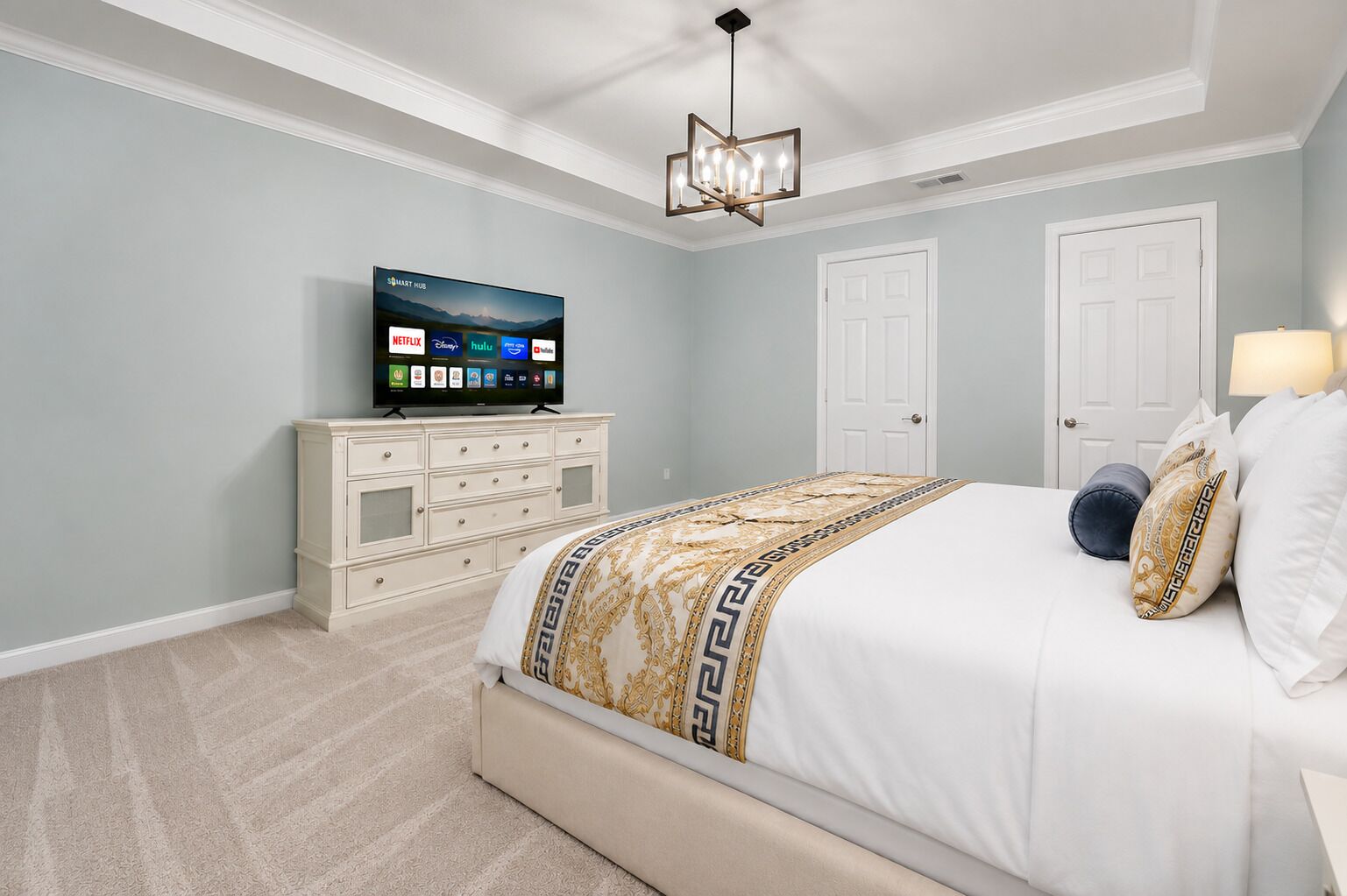 A bedroom with a bed, a TV on a dresser, and a ceiling fan.