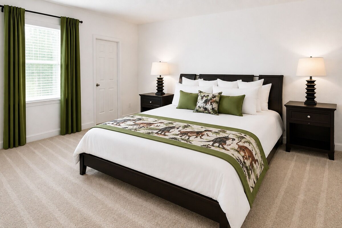 A bedroom with a bed, two bedside tables, a door, and a window with curtains.