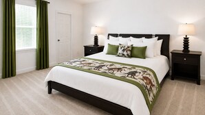 Un dormitorio con cama, dos mesitas de noche, una puerta y una ventana con cortinas.