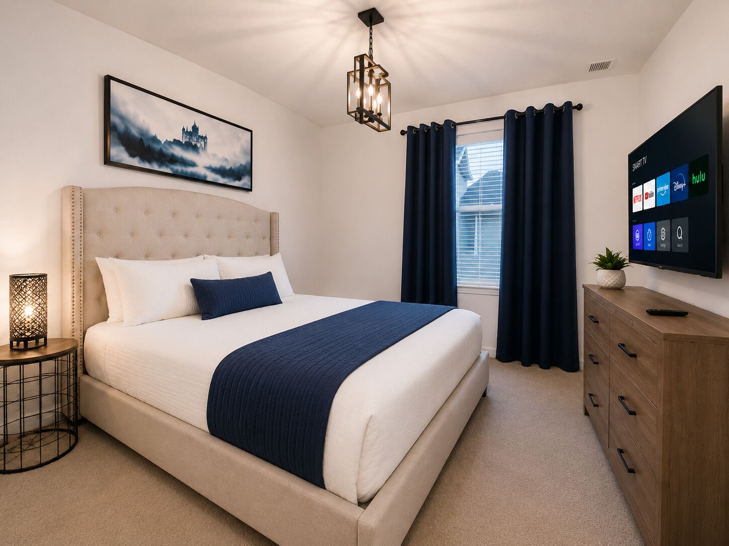 A bedroom with a bed, a bedside table with a lamp, a wall-mounted TV, and a window with curtains.
