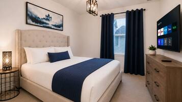 A bedroom with a bed, a bedside table with a lamp, a wall-mounted TV, and a window with curtains.