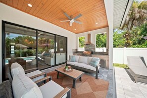 An outdoor living area with a pool, seating, and a barbecue. - New! Dream Chaser • New Luxury Build • Heated Saltwater Pool/Spa • 1 Mile to Vanderbilt Beach! (Naples)