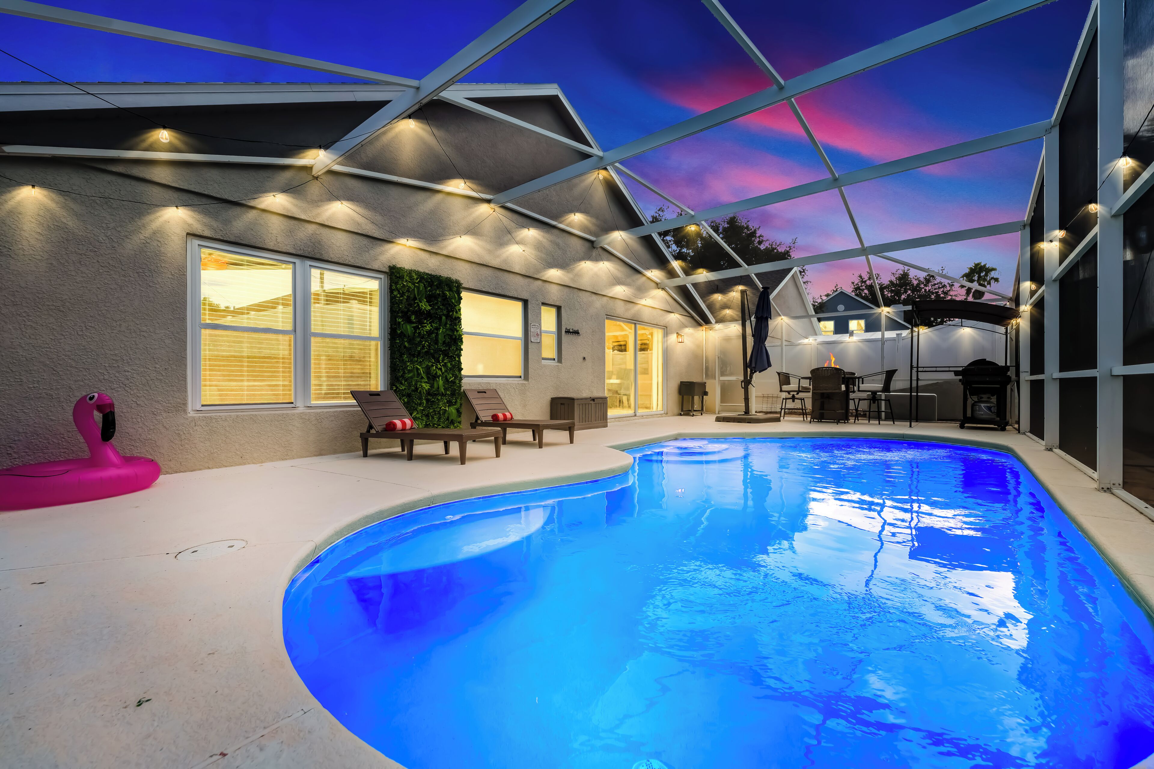 A swimming pool with lounge chairs and a covered patio area.