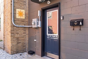 A building entrance with a door labeled '436 W. Front St. Units 1, 2 & 3 Upstairs.' - Three Downtown Apartments | large groups | private | laundry (Traverse City)