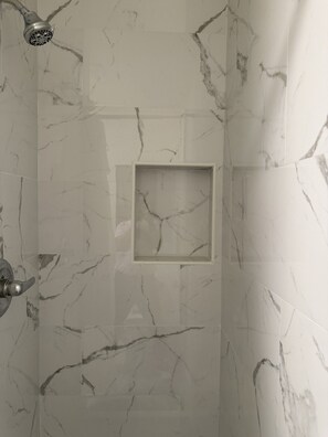 A bathroom with marble walls and a shower area. - Hollywood Highland Hotel & Hostel (Los Angeles)