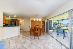 A modern kitchen with a dining area and a balcony with a view. - NEW Keauhou Palena Sleeps 3 (Kailua Kona)