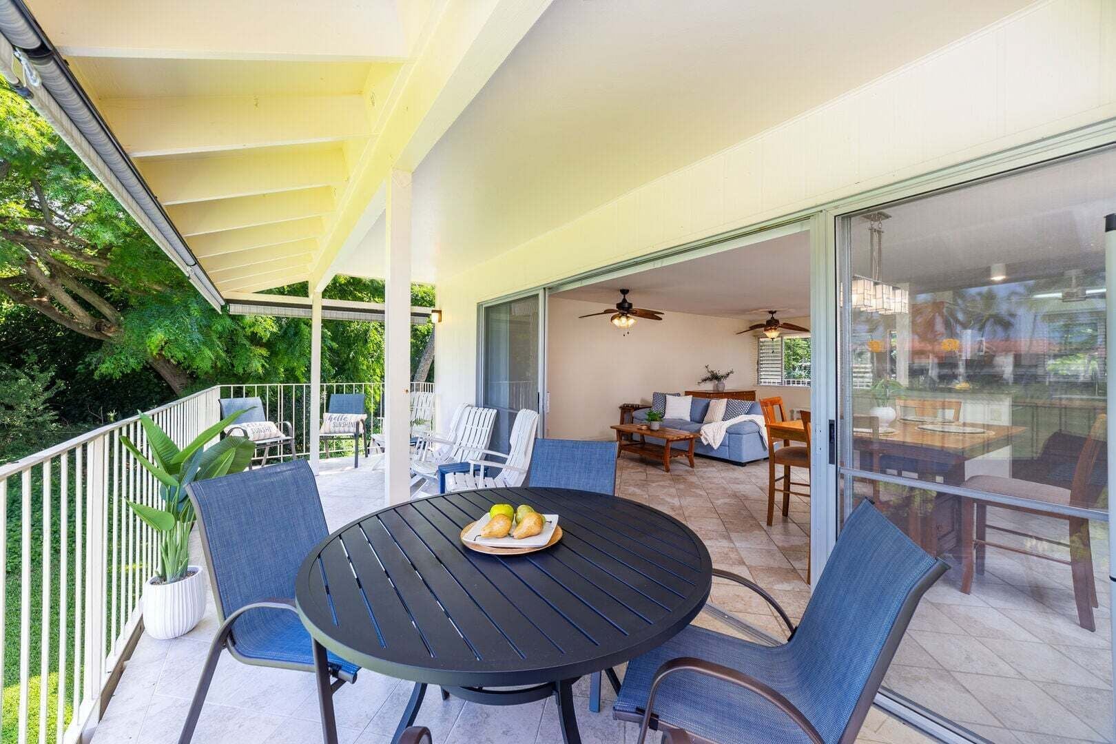 A covered patio with a round table, chairs, and a dining area.