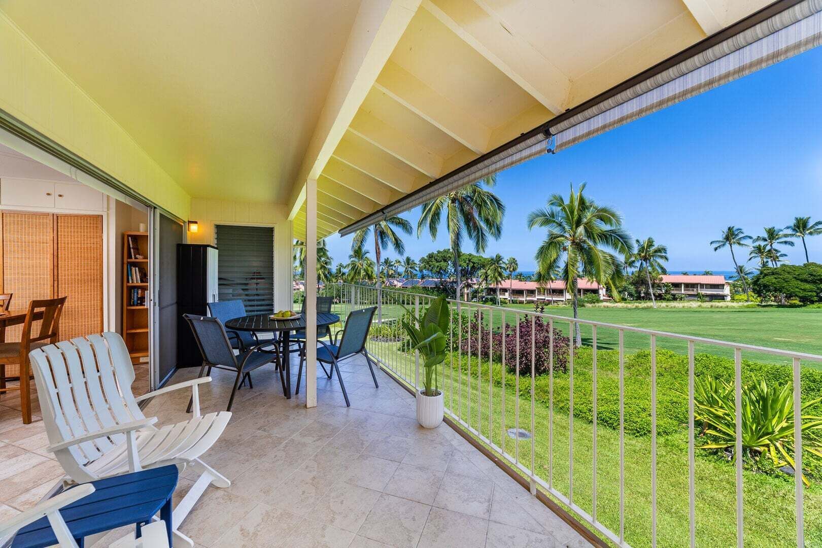 A balcony with a view of a golf course and palm trees.