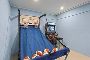 A basketball hoop with a blue net and a Supercade arcade machine. - Coastal Beauty - Canal Front, Dock, Pool, Spa, Game Room by Anna Maria Life Vacation Rentals (Anna Maria)