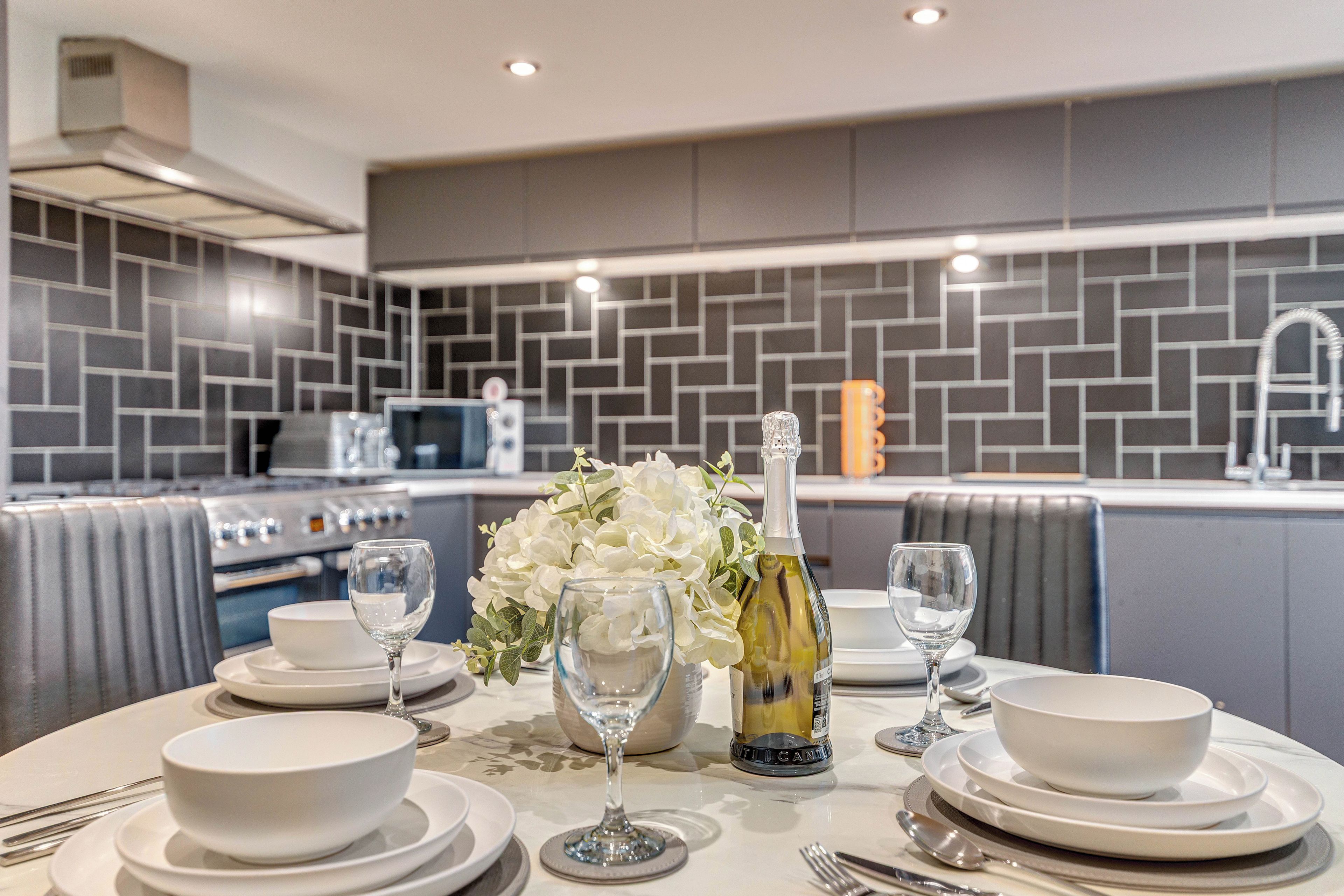 A modern kitchen with a dining area set up for a meal.