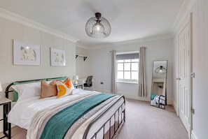 A bedroom with a bed, a desk, a chair, a window with curtains, a hanging light fixture, and a mirror. - Spacious 5 -bed Georgian Townhouse I 4 bathrooms I Walk to Liverpool one. (Liverpool)
