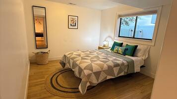 Une chambre à coucher avec un lit, une fenêtre, un miroir et un tapis.