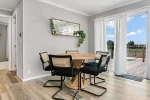 A dining area with a round table, four chairs, a mirror, and a view of the outdoors. - 3/2 Pet friendly w/ fee Hill Country home w/ hot tub, fire-pit, views & more (Fredericksburg)