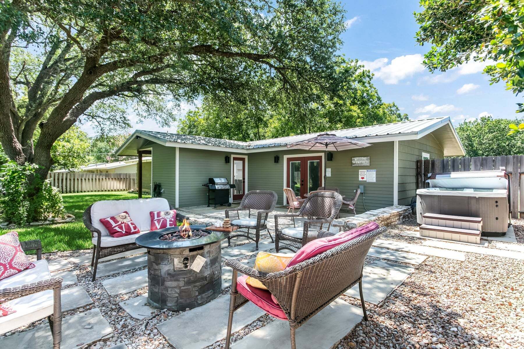 A patio area with outdoor furniture, a fire pit, and a hot tub.