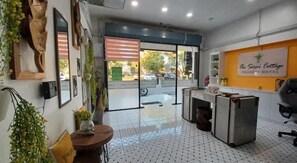 A hotel reception area with a tiled floor, a reception desk, and a wall-mounted sign. - The Serai Cottage Transit Hotel (Kuala Terengganu)