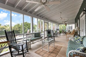 A covered porch with outdoor furniture, including chairs and a sofa, and a ceiling fan. - The Ark - Add to the History and Memories of Sullivan (Sullivans Island)