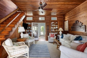 A wooden interior with a staircase, white furniture, and a ceiling fan. - The Ark - Add to the History and Memories of Sullivan (Sullivans Island)