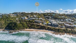 A coastal residential area with houses, a beach, and a clear sky. - Azure Dreaming - Beachfront Villa @ Coolum Beach (Coolum Beach)